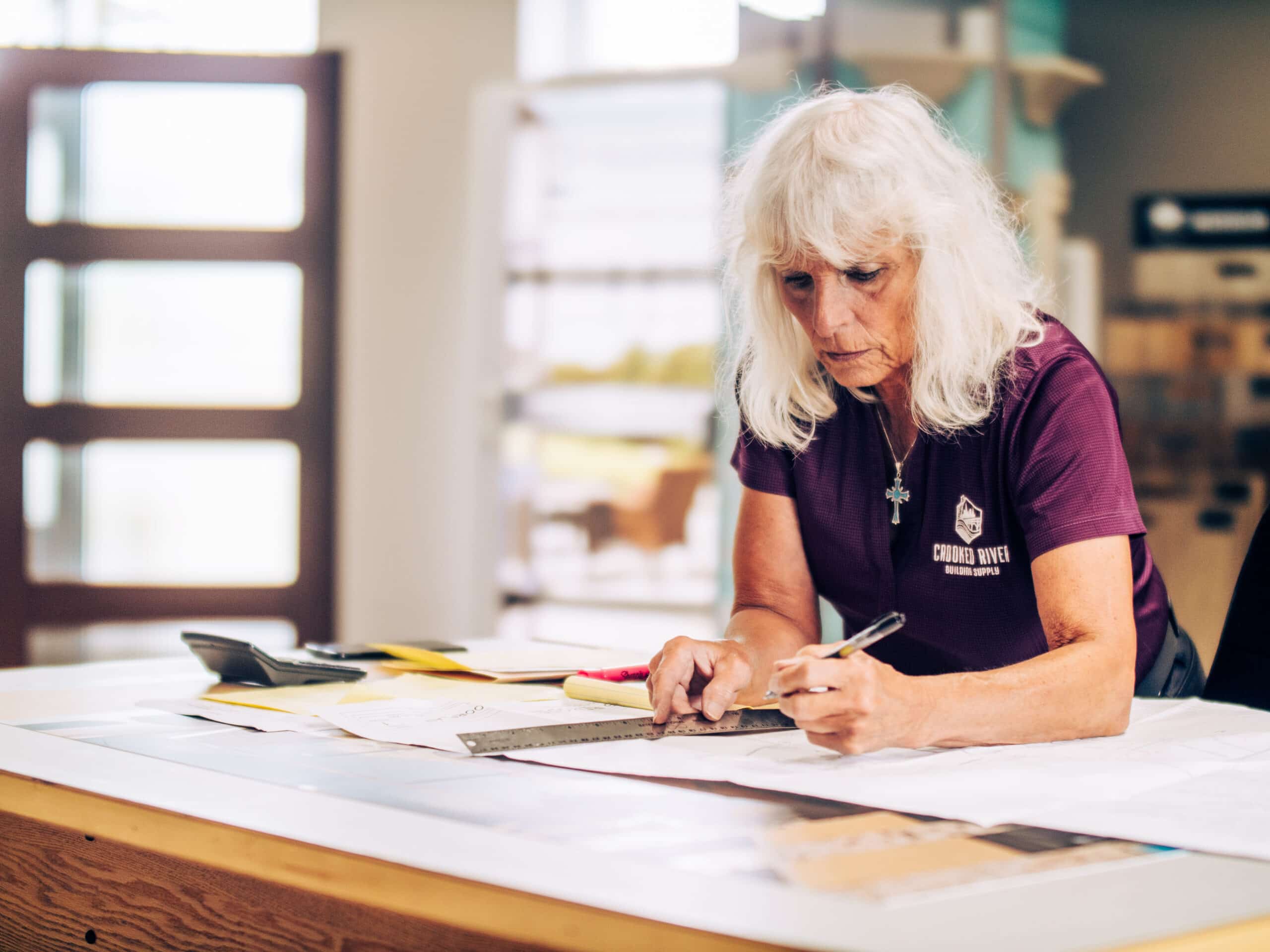 Person at desk working on blueprints